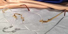 Load image into Gallery viewer, Side view of Traditionals Rimless gold metal eyeglasses with oval lenses
